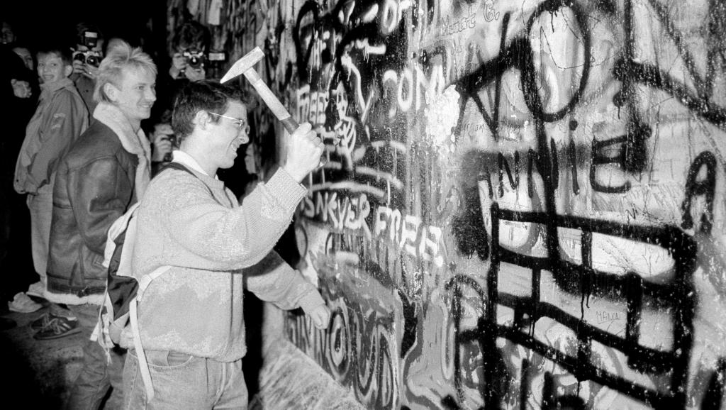 1989年11月9日，在西德宣布開放邊界後，一位男子用鐵錘敲擊靠近勃登堡門附近的柏林牆。