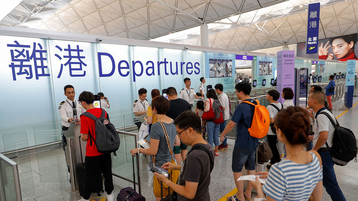在中、港邊境，中國海關近日大規模截查香港旅客，更強製翻查他們手機內的私資訊。圖為2019年8月14日，旅客在香港機場登機口辦理登機手續。（美聯社）