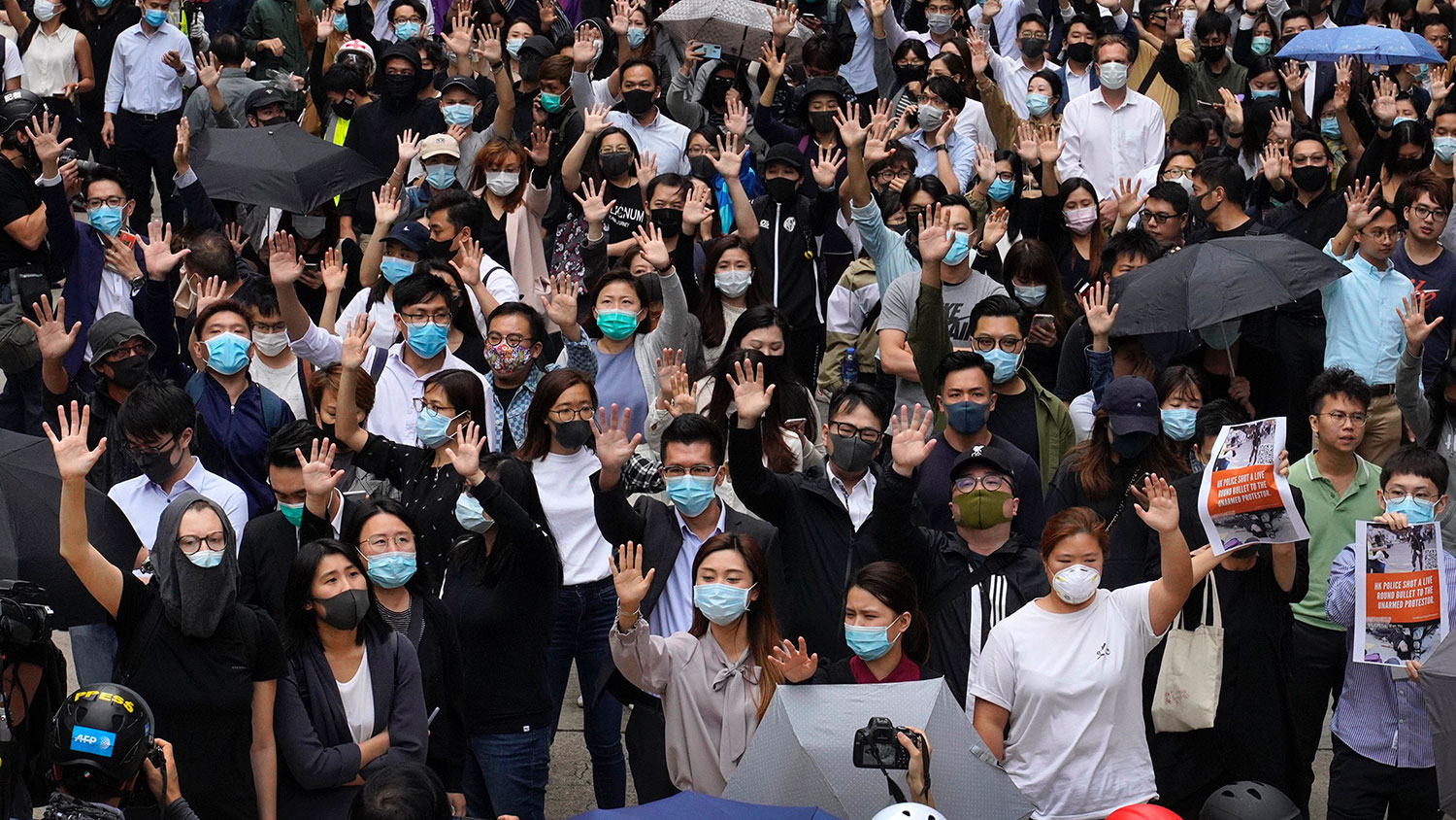 2019年11月12日，香港辦公室工作人員和親民主示威者舉起5隻手指，代表“五大訴求，缺一不可”。（美聯社）