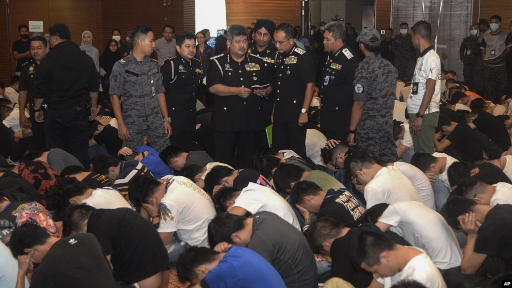 馬來西亞移民官2019年11月21日在布城檢查被關押的中國人的旅行證件。馬來西亞移民官星期四說，他們破獲了一個中國網絡欺詐集團，逮捕了680名中國嫌犯。