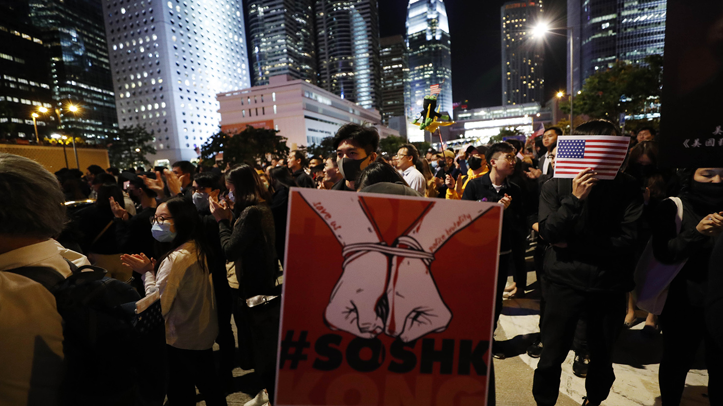2019年11月28日，香港抗議者舉著一副被烤著手銬的手的圖片進行抗議。（美聯社）