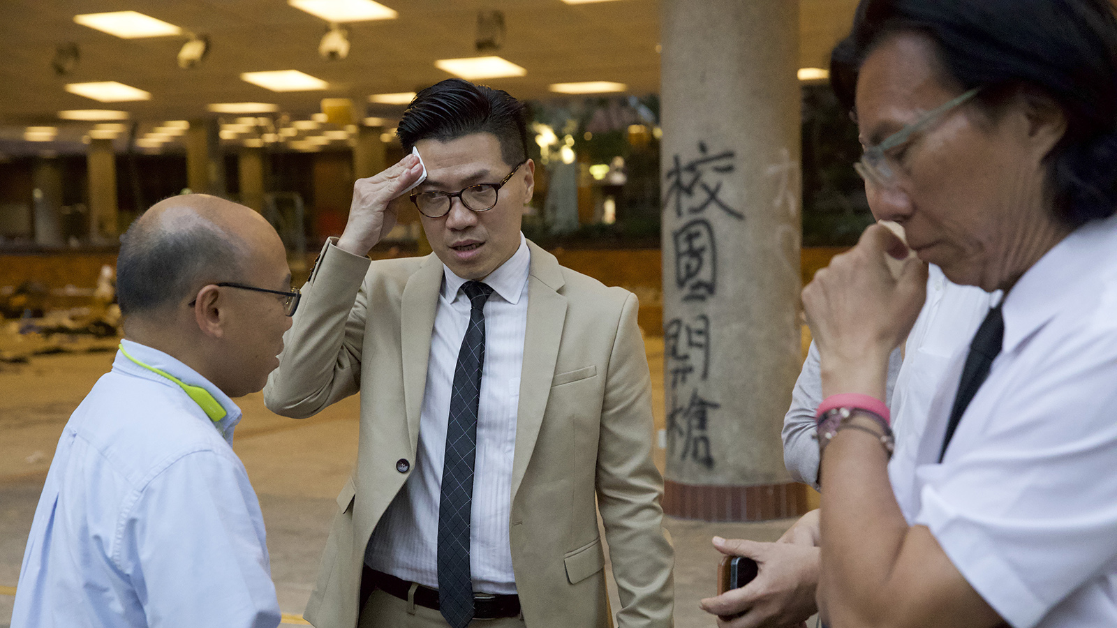 2019年11月25日，香港新當選的立法會議員黃國桐（右）和範國威（中）和香港理工大學的抗議學生見麵。（美聯社）