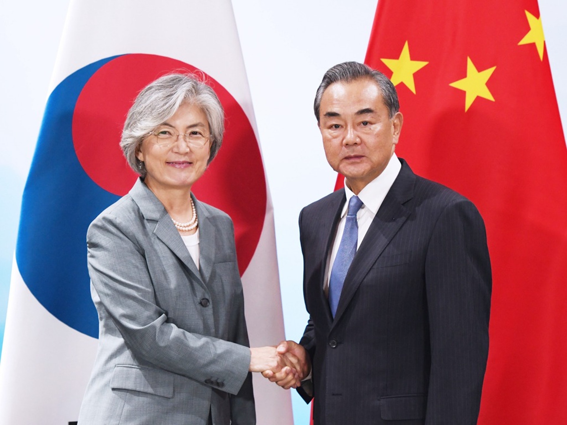 中國外長王毅（右）在12月初的韓國之行名義上是應韓國外長康京和邀請前往，但外界大都清楚，他此行更多是為此後的首腦會議打前站。（新華社）