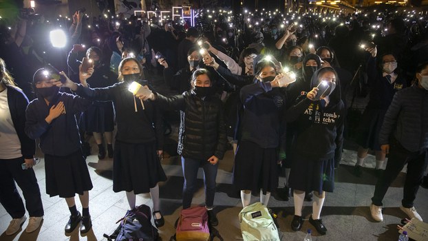 2019年12月13日一些香港抗議者在演唱《榮光歸香港》的時候揮舞著手機。（美聯社）