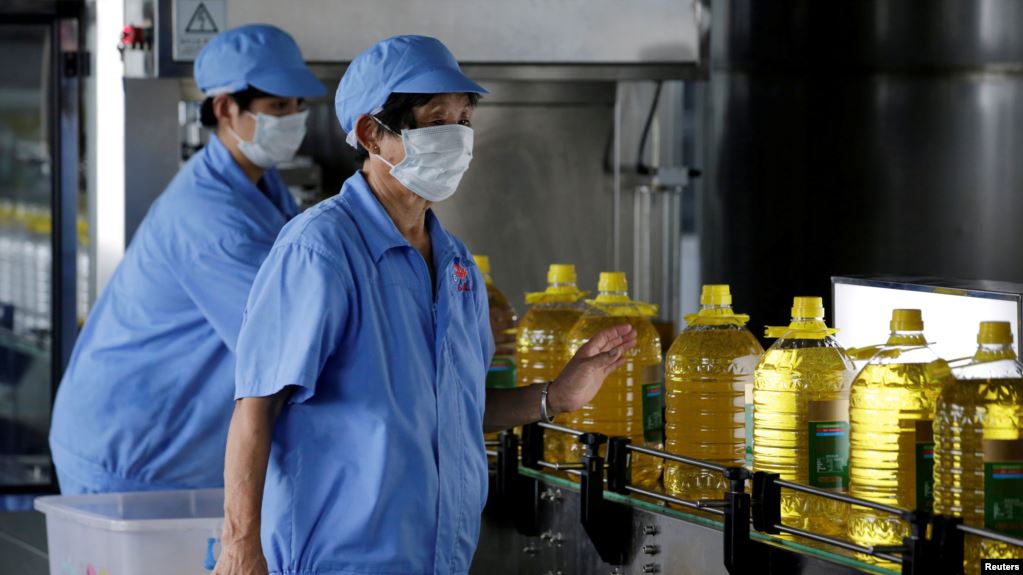 2018年7月4日，中國山東省曲阜市糧油工業和進出口公司工廠的工人在瓶裝豆油的生產線上。這些豆油是用美國大豆提煉的。