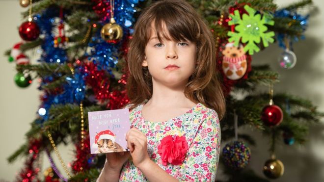 倫敦女孩弗洛倫斯·維迪科姆拿著她買到的Tesco套裝聖誕卡（22/12/2019）