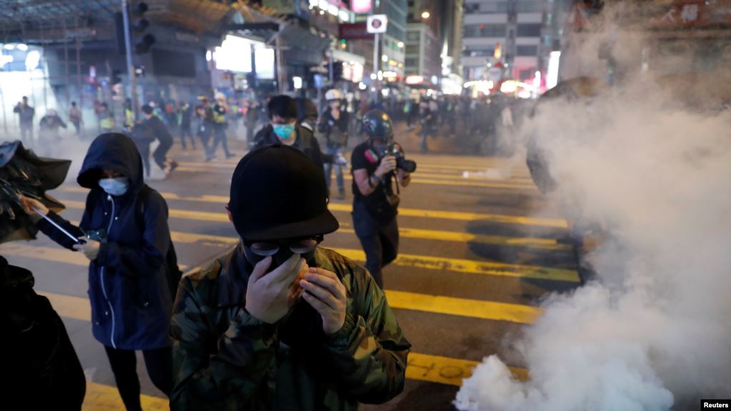香港聖誕節平安夜舉行的抗議活動中反政府示威者逃離警察發射的催淚彈。（2019年12月24日）