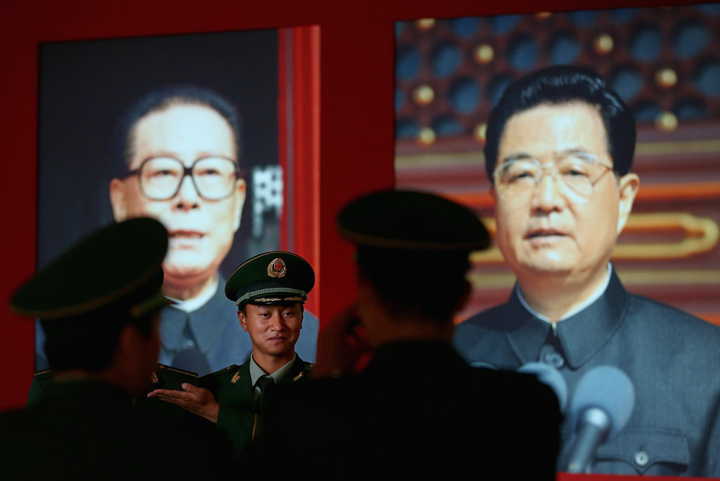 2012年11月8日，警察站在江澤民（左）和時任中共領導人的胡錦濤肖像前。