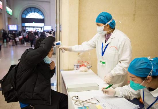 1月22日，漢口火車站，醫護人員對進站旅客的體溫進行檢測