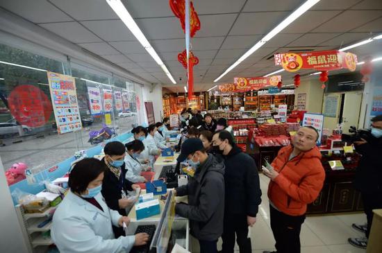 1月23日，在湖南長沙一家老百姓大藥房內，市民排隊購買口罩