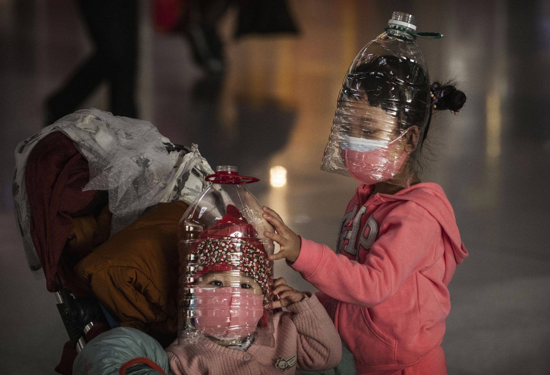 2020年1月30日，小童除了戴上了口罩，還以蒸餾水樽作為頭套防疫。（Kevin Frayer／Getty Images）