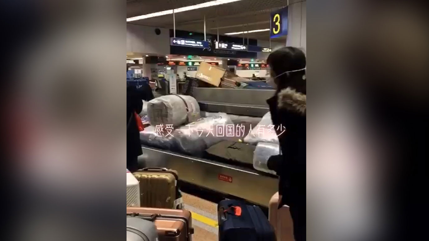 北京國際機場行李傳送帶上，眾多海外華人抵達。（視頻截圖）