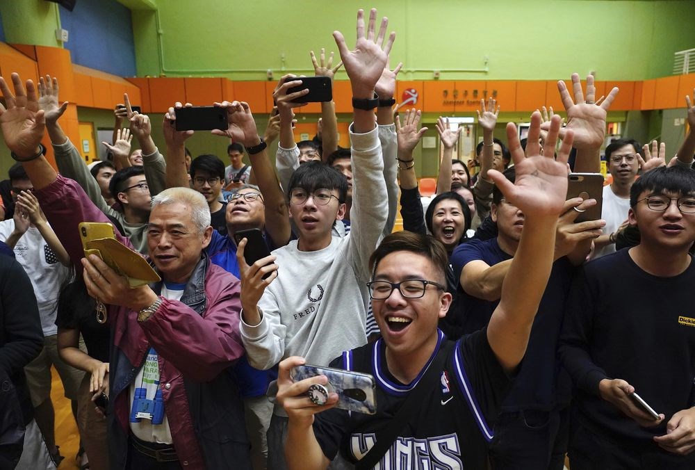 香港泛民主派在區議會選舉中大獲全勝，篤定將可以取得特首選舉委員會1200席中的117席。圖為泛民派候選人確定當選後，支持者歡呼慶祝。（美聯社）