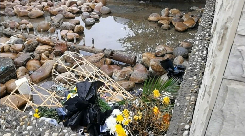 6月12日，店铺对面的水沟里还堆放着残留的花圈。 （南方周末记者 高伊琛/图）