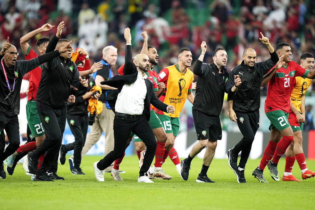 10日摩洛哥总教头雷格拉吉（Walid Regragui）与球员庆祝击败葡萄牙闯进半决赛。（图／美联社）