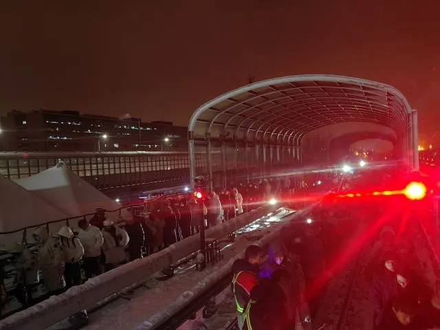 图为14日西二旗地铁站台，乘客冒雪从地铁轨道上撤离。摄影/马晨晨